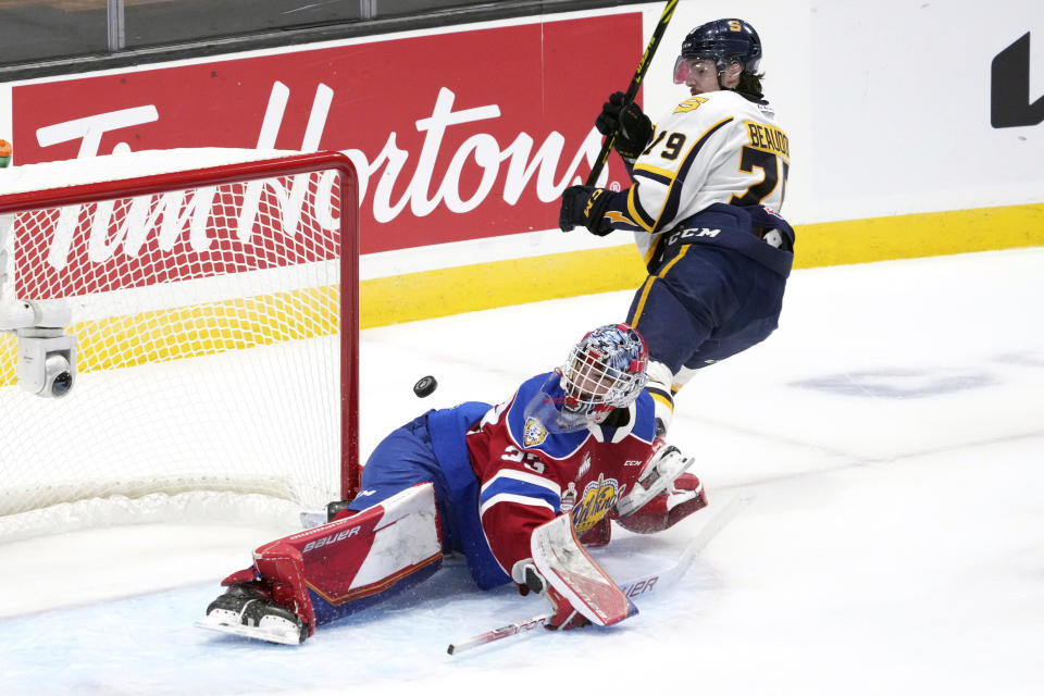 Edmonton Oil Kings goaltender Sebastian Cossa, left, makes a save on Shawinigan Cataractes' Charles Beaudoin during the first period of the Memorial Cup hockey game in Saint John, New Brunswick, Tuesday, June 21, 2022. (Darren Calabrese/The Canadian Press via AP)