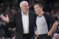 San Antonio Spurs head coach Gregg Popovich, left, talks to referee Nick Buchert during the first half of an NBA preseason basketball game against the New Orleans Pelicans, Sunday, Oct. 13, 2019, in San Antonio. (AP Photo/Darren Abate)