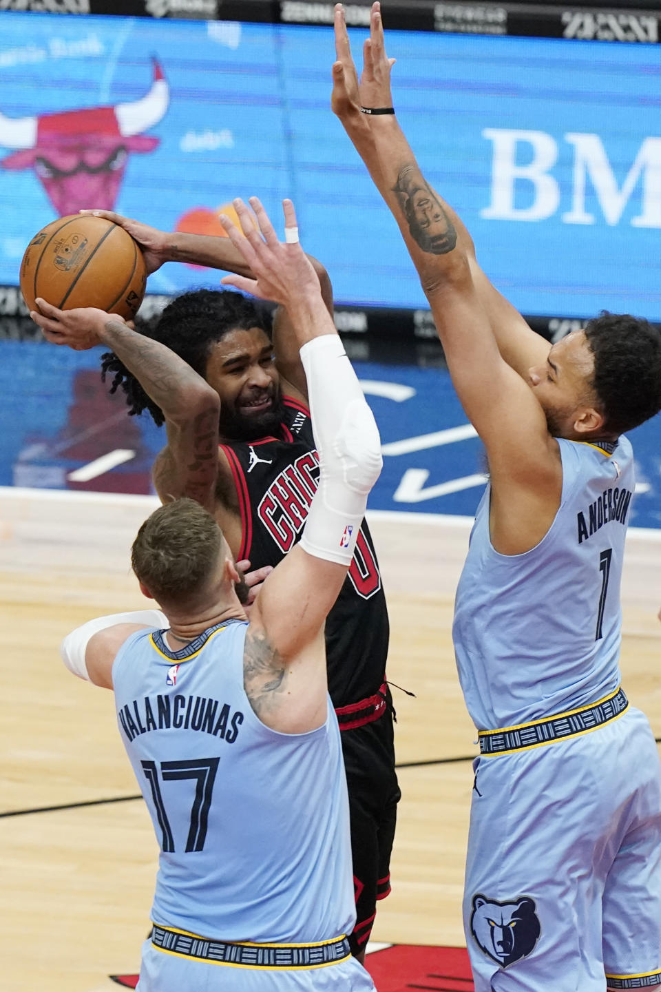 Chicago Bulls guard Coby White, center, drives to the basket as Memphis Grizzlies center Jonas Valanciunas (17) and forward Kyle Anderson guard during the second half of an NBA basketball game in Chicago, Friday, April 16, 2021. (AP Photo/Nam Y. Huh)