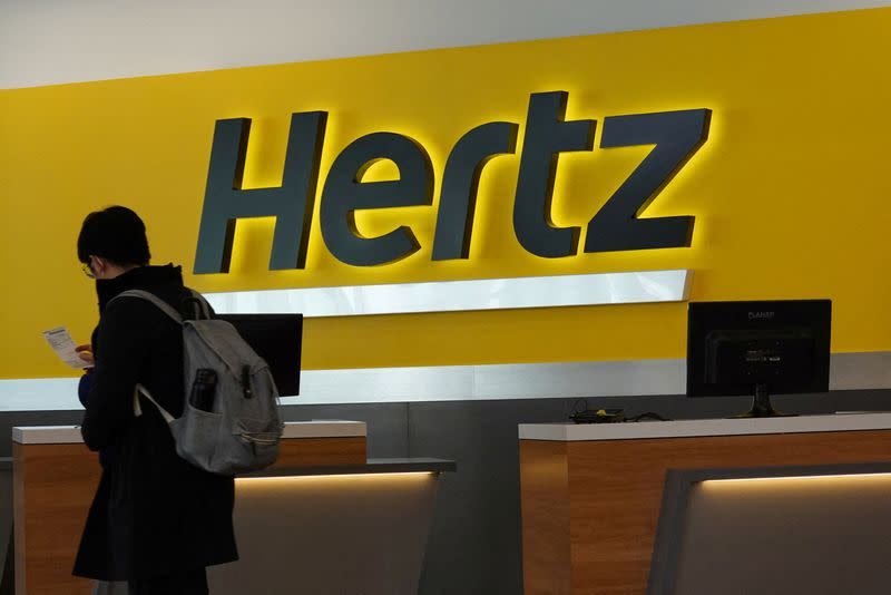 FILE PHOTO: A person walks by the counter at Hertz rental car at John F. Kennedy International Airport in Queens, New York City