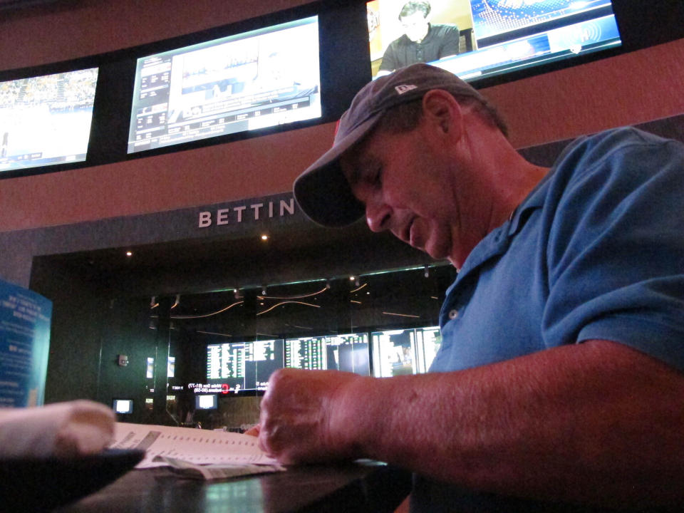 In this Sept. 4, 2019 photo, Andy Lanni of Oceanview, N.J. checks the odds at the sports book in the Borgata casino in Atlantic City, N.J. As the second NFL season begins following a U.S. Supreme Court decision clearing the way for legal sports betting, the industry is growing larger and ever-more mobile in the U.S. (AP Photo/Wayne Parry)