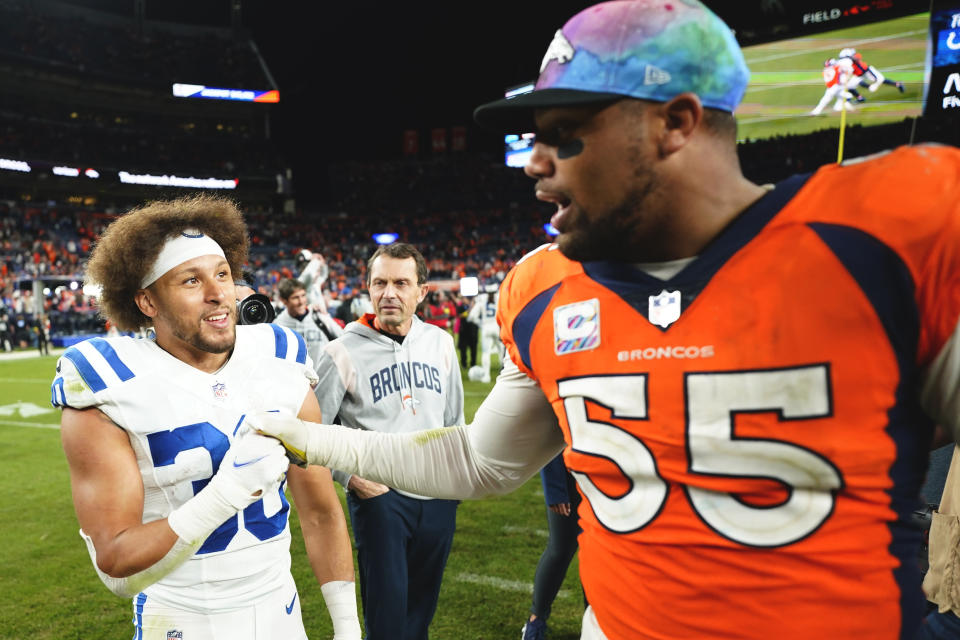 Denver Broncos linebacker Bradley Chubb (55) and Indianapolis Colts running back Phillip Lindsay (30) meet at mid field an NFL football game, Thursday, Oct. 6, 2022, in Denver. The Colts defeated the Broncos 12-9 in overtime. (AP Photo/Jack Dempsey)