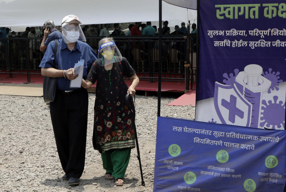 People wearing face shields and masks as a precaution against the coronavirus arrive to receive COVID-19 vaccine in Mumbai, India, Thursday, April 29, 2021. India set another global record in new virus cases Thursday, as millions of people in one state cast votes despite rising infections and the country geared up to open its vaccination rollout to all adults amid snags. (AP Photo/Rajanish Kakade)