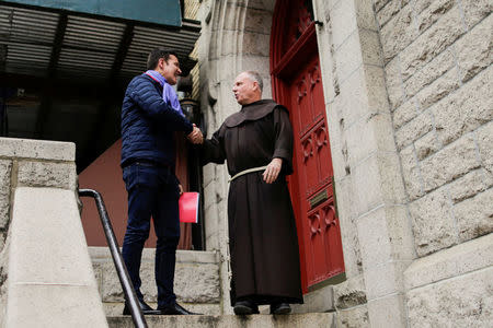 Chilean victim of clerical sexual abuse Juan Cruz shakes hands with a church member as he exits a meeting with investigator, Archbishop Charles Scicluna of Malta in New York City, New York, U.S., February 17, 2018. REUTERS/Eduardo Munoz