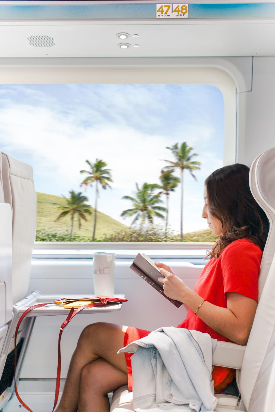 This Brightline image depicts a passenger riding in a train on the future Orlando-to-South Florida rail route.