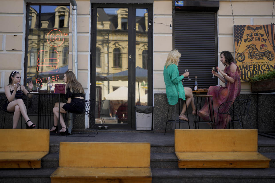 Women drink at a bar in Kyiv, Ukraine, Friday, June 10, 2022. With war raging on fronts to the east and south, the summer of 2022 is proving bitter for the Ukrainian capital, Kyiv. The sun shines but sadness and grim determination reign. (AP Photo/Natacha Pisarenko)