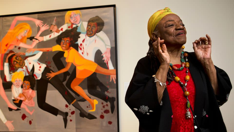 Faith Ringgold is pictured during a preview for a 2013 exhibition at the National Museum of Women in the Arts in Washington, D.C., with her 1967 painting "American People Series #20: Die" visible, in part, in the background. "I didn't want people to be able to look, and look away," Ringgold said at the preview. "I want them to look and see. I want to grab their eyes and hold them, because this is America." - Jacquelyn Martin/AP