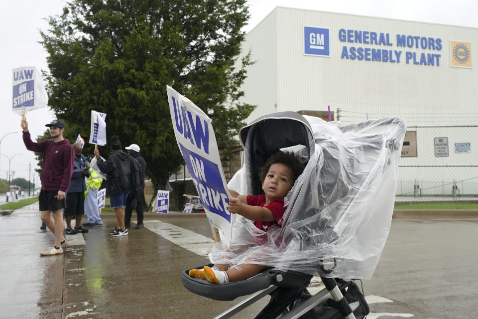 Auhsten Bartlett, 18-months old, holds a sign while his parents Edward Bartlett, not visible, a General Motors trim department employee, and Trista Bartlett picket with others outside the company's assembly plant, Tuesday, Oct. 24, 2023, in Arlington, Texas. (AP Photo/Julio Cortez)
