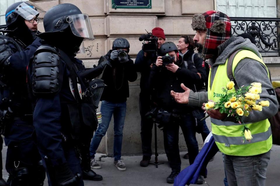 A protester faces off with riot police (REUTERS)