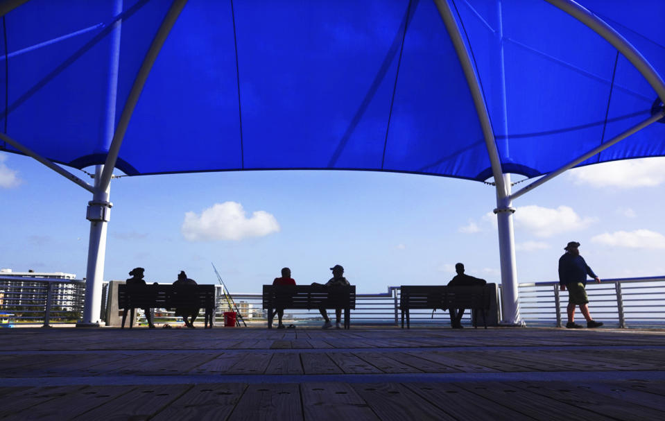People enjoy the view at the Fisher Family Pompano Beach Pier, Wednesday, Sept. 2, 2020, in Popano Beach, Fla. Broward County beaches will remain open for the upcoming Labor Day weekend holiday. (Joe Cavaretta/South Florida Sun-Sentinel via AP)
