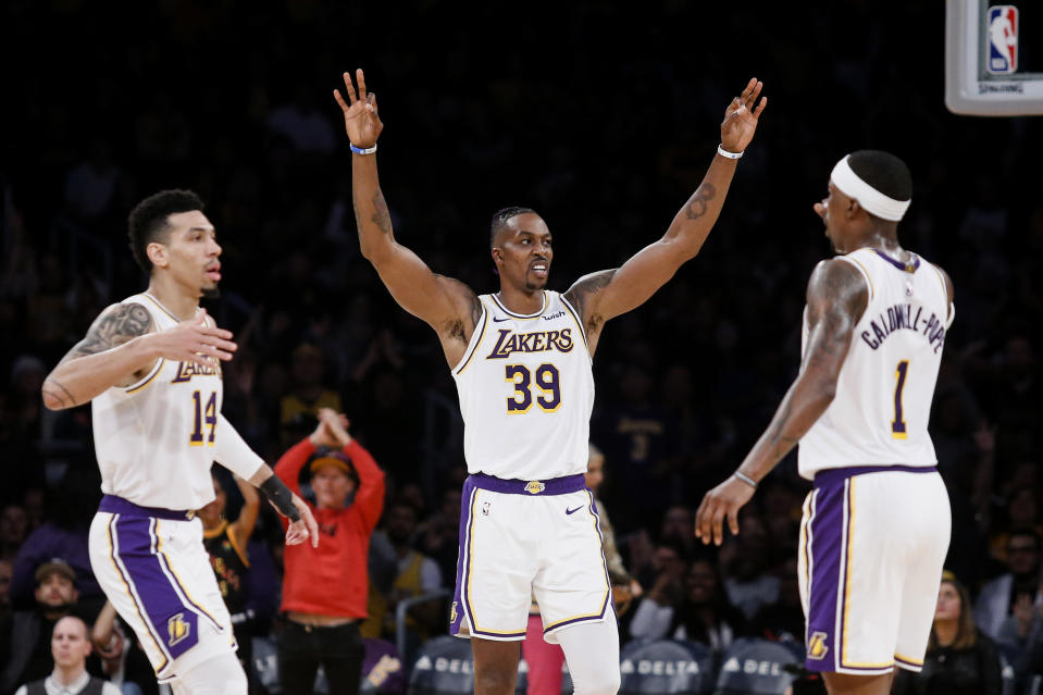 Los Angeles Lakers' Danny Green (14) celebrates with teammates Dwight Howard (39) and Kentavious Caldwell-Pope (1) after making a 3-pointer during the first half of an NBA basketball game, Sunday, Dec. 8, 2019, in Los Angeles. (AP Photo/Ringo H.W. Chiu)