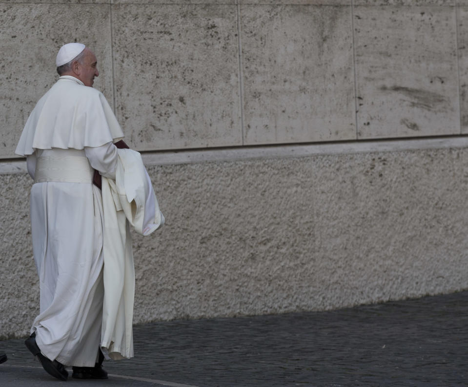 Pope Francis leaves at the end of the morning session of an extraordinary consistory in the Synod hall at the Vatican City, Friday, Feb. 21, 2014. Pope Francis is leading a two-day meeting urging his cardinals to find "intelligent, courageous" ways to help families under threat today without delving into case-by-case options to get around Catholic doctrine. He said the church must find ways to help families with pastoral care that is "full of love."(AP Photo/Alessandra Tarantino)