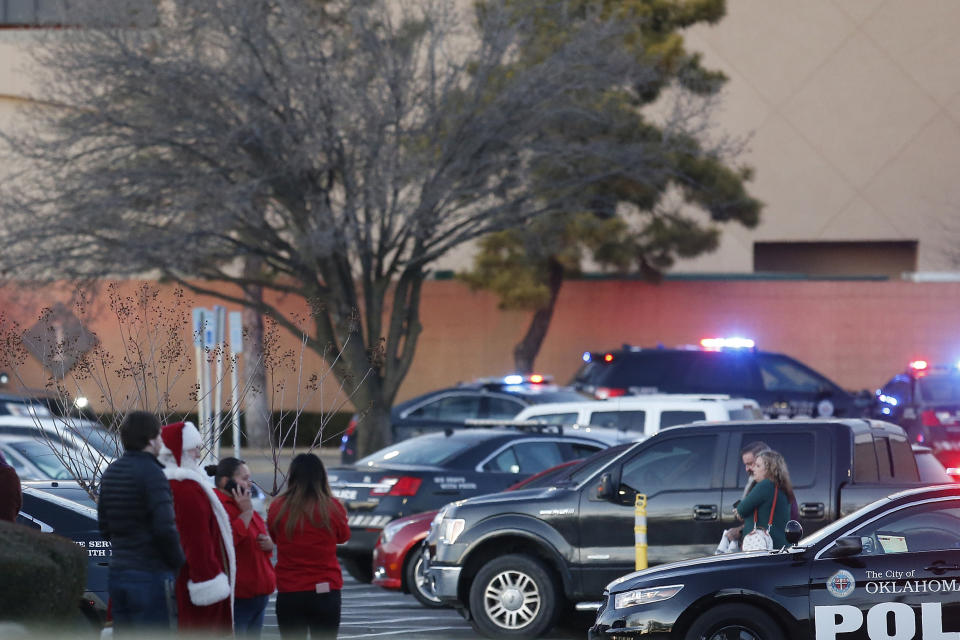 Bystanders, including one dressed as Santa Claus, watch as police clear Penn Square Mall following a shooting Thursday, Dec. 19, 2019, in Oklahoma City. One person was shot at the mall during what police are calling a disturbance involving two people. (AP Photo/Sue Ogrocki)