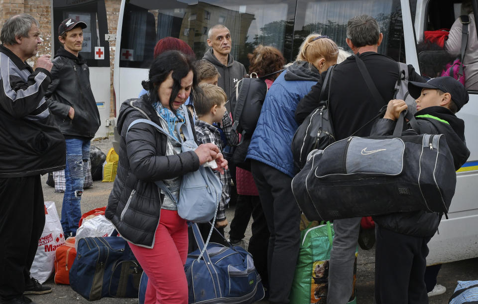 People board transport during an evacuation of civilians in Soledar, Donetsk region, Ukraine, Tuesday, May 24, 2022. (AP Photo/Andriy Andriyenko)