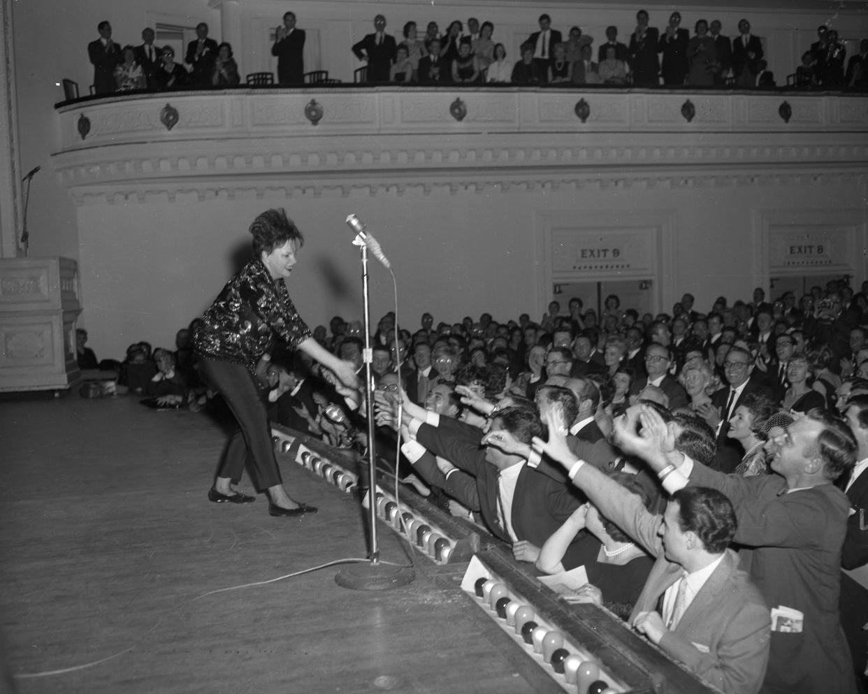 Judy Garland reaches down offstage to dozens of outstretched hands of male audience members at Carnegie Hall, on April 24, 1961.(Photo by Frank Russo/NY Daily News via Getty Images)