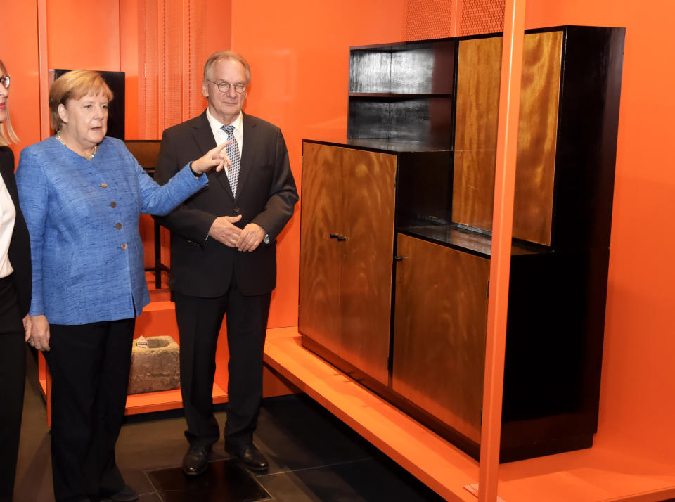 German Chancellor Angela Merkel, left, and Reiner Haseloff, governor of the German state of Saxony-Anhalt, look at furniture during the official opening of the new Bauhaus Museum, built for the centenary of the founding of the Bauhaus, in Dessau, Germany Sunday, Sept. 8, 2019. (AP Photo/Jens Meyer,Pool)