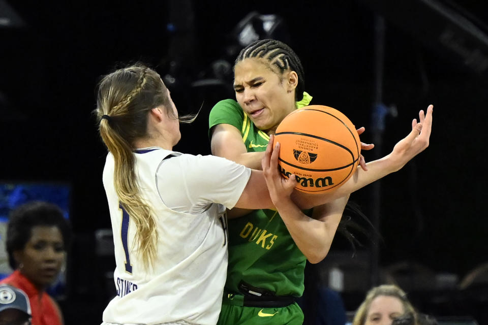 Washington guard Hannah Stines, left, and Oregon guard Endyia Rogers battle for the ball during the second half of an NCAA college basketball game in the first round of the Pac-12 women's tournament Wednesday, March 1, 2023, in Las Vegas. (AP Photo/David Becker)