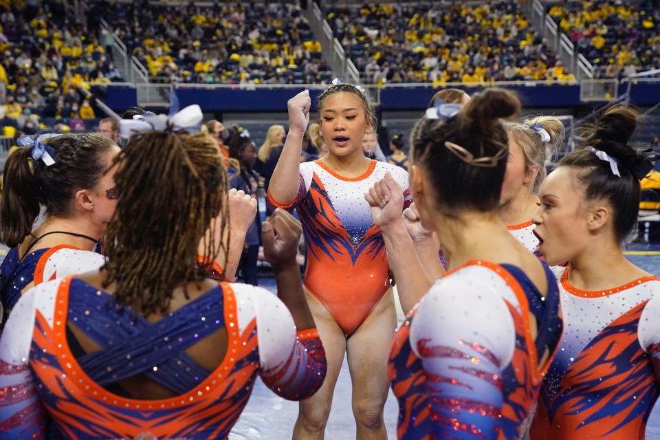 Suni Lee and her Auburn teammates huddle up during a meet at the University of Michigan.