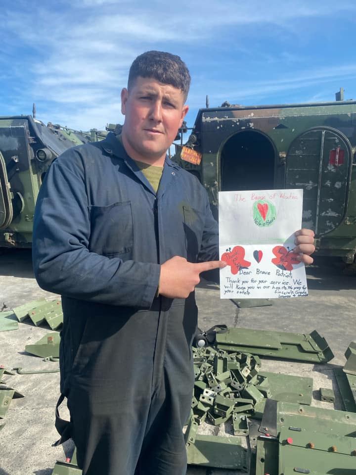 A service member at a California military base points to a valentine card sent by the Weymouth Rotary Club.