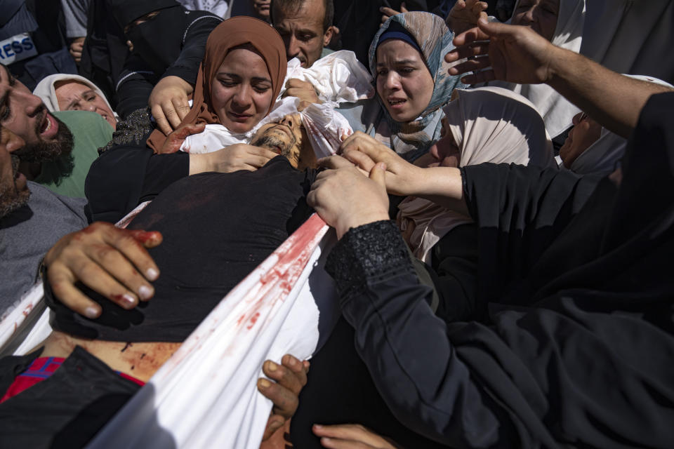 FILE - Palestinians carry the body of a man killed during fighting with Israeli forces, in Gaza City, Saturday, Oct. 7, 2023. The militant Hamas rulers of the Gaza Strip carried out an unprecedented, multi-front attack on Israel at daybreak Saturday, firing thousands of rockets as dozens of Hamas fighters infiltrated the heavily fortified border in several locations by air, land, and sea and catching the country off-guard on a major holiday. (AP Photo/Fatima Shbair, File)