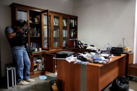 A local photographer makes a video of journalist Carlos Fernando Chamorro's office, which was raided Thursday night by the national police in Managua, Nicaragua December 14, 2018.REUTERS/Oswaldo Rivas