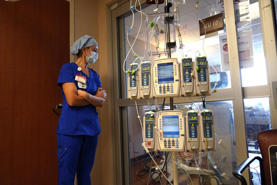 FILE - In this Aug. 17, 2021, file photo, nursing coordinator Beth Springer looks into a patient's room in a COVID-19 ward at the Willis-Knighton Medical Center in Shreveport, La. COVID-19 deaths in the U.S. have climbed to an average of more than 1,900 a day for the first time since early March, with experts saying the virus is preying largely on a select group: 71 million unvaccinated Americans. (AP Photo/Gerald Herbert, File)