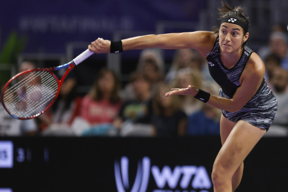 Caroline Garcia, of France, follows through on a serve to Maria Sakkari, of Greece, in the singles semifinals of the WTA Finals tennis tournament in Fort Worth, Texas, Sunday, Nov. 6, 2022. (AP Photo/Ron Jenkins)