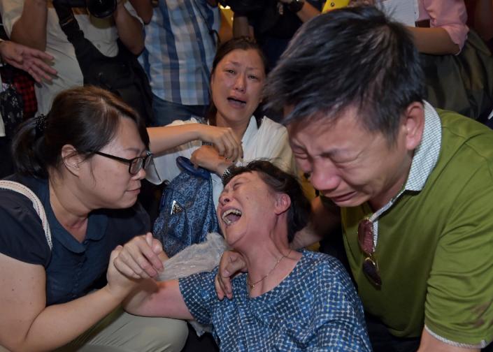 Relatives of a Chinese tourist killed in a bomb blast outside a religious shrine grieve after identifying the body at the Institute of Forensic Medicine in Bangkok on August 18, 2015 (AFP Photo/Ponrchai Kittwongsakul )