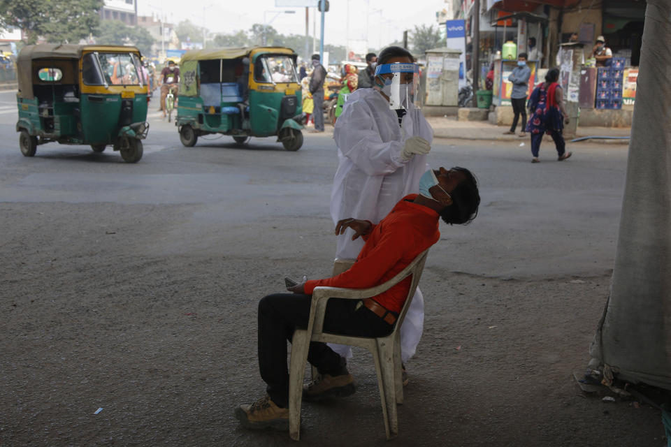 A health worker takes a nasal swab sample of a man to test for COVID-19 in Ahmedabad, India, Monday, Jan. 4, 2021. India on Sunday authorized two COVID-19 vaccines, paving the way for a huge inoculation program to stem the coronavirus pandemic in the world's second most populous country. (AP Photo/Ajit Solanki)