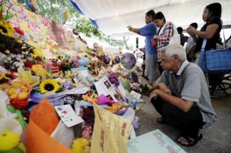 A man reads tributes to Singapore's former prime minister Lee Kuan Yew, at the Singapore General Hospital, March 23, 2015. REUTERS/Timothy Sim