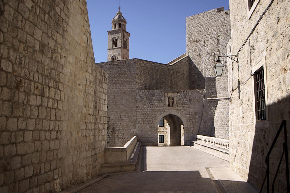 This Tuesday, March 17, 2020 photo shows deserted street and the city walls in Dubrovnik old town, Croatia. Just outside the majestic walls of Croatia’s medieval citadel city of Dubrovnik lies a cluster of small stone houses that today serve as an art and clubbing hub. But as the coronavirus spreads across the globe, many are being reminded of the Lazarettos, called Lazareti in Croatian, originally used as an ancient quarantine area that helped keep infectious diseases away. (AP Photo/Darko Bandic)