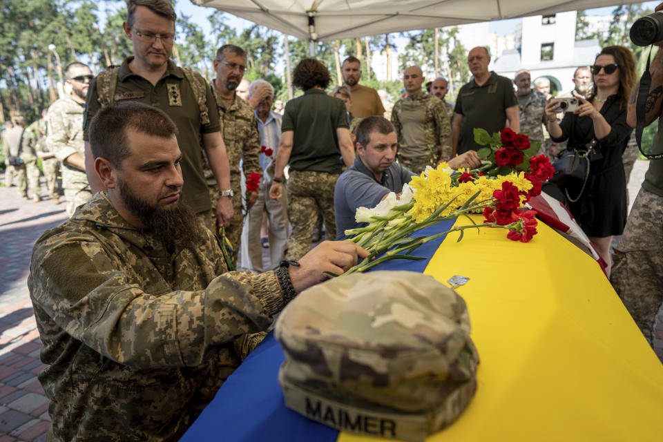 A Ukrainian serviceman pays his last respects to his comrade Nicholas Maimer, a U.S. citizen and Army veteran who was killed during fighting in Bakhmut against Russian forces, in Ukrajinka, Ukraine, Wednesday, July 19, 2023. (AP Photo/Evgeniy Maloletka)