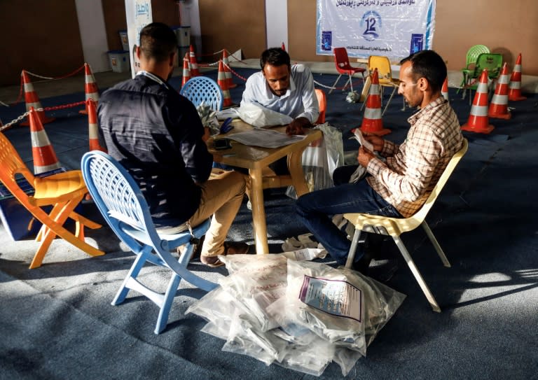 Iraqi electoral commission employees manually count ballots in the central city of Najaf on May 13, 2018