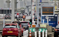 People queue in line to check-in for the Euro Tunnel train to the U.K. in Coquelles, France, Friday Aug.14, 2020. British holiday makers in France were mulling whether to return home early Friday to avoid having to self-isolate for 14 days following the U.K. government's decision to reimpose quarantine restrictions on France amid a recent pick-up in coronavirus infections. (AP Photo/Olivier Matthys)