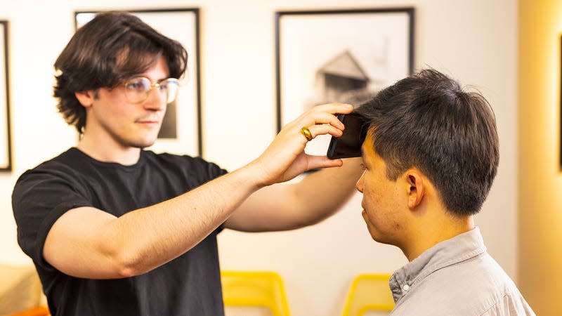 Shown here is lead author Joseph Breda (left), a UW doctoral student in the Paul G. Allen School of Computer Science & Engineering, measuring Richard Li’s temperature using a smartphone app.