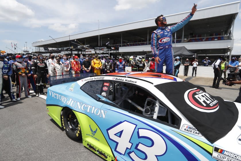 Driver Bubba Wallace takes a selfie with himself and other drivers that pushed his car to the front in the pits of the Talladega Superspeedway prior to the start of the NASCAR Cup Series auto race at the Talladega Superspeedway in Talladega Ala., Monday June 22, 2020. In an extraordinary act of solidarity with NASCAR's only Black driver, dozens of drivers pushed the car belonging to Bubba Wallace to the front of the field before Monday's race as FBI agents nearby tried to find out who left a noose in his garage stall over the weekend. (AP Photo/John Bazemore)