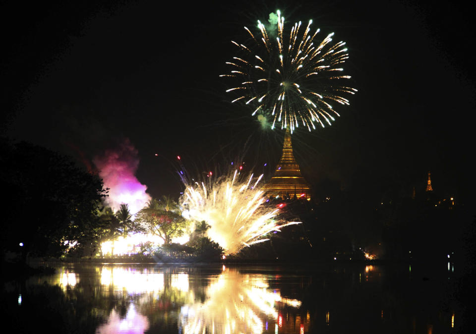 Fireworks explode to celebrate the arrival of the New Year at National Kandawgyi park in Yangon, Myanmar on Wednesday, Jan. 1, 2014. (AP Photo/Khin Maung Win)