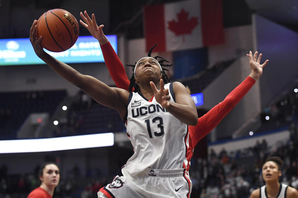 Connecticut's Christyn Williams (13) goes up for a basket as St. John's Rayven Peeples, back, defends in the first half of an NCAA college basketball game, Friday, Feb. 25, 2022, in Hartford, Conn. (AP Photo/Jessica Hill)