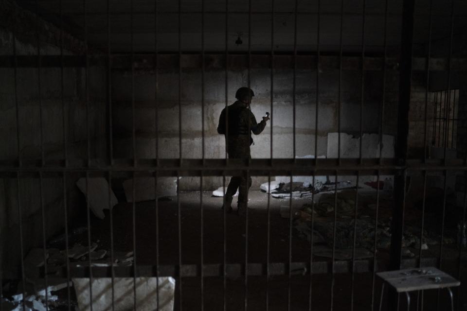 FILE - A Ukrainian serviceman stands in a basement which, according to Ukrainian authorities, was used as a torture cell during the Russian occupation, in the retaken village of Kozacha Lopan, Ukraine, Sept. 17, 2022. In a deliberate, widespread campaign, Russian forces systematically targeted influential Ukrainians, nationally and locally, to neutralize resistance through detention, torture and executions, an Associated Press investigation has found. The strategy appears to violate the laws of war and could help build a case for genocide. (AP Photo/Leo Correa, File)