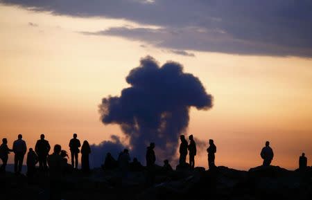 Turkish Kurds watch the smoke rises from Syrian town of Kobani near the Mursitpinar border crossing, on the Turkish-Syrian border in the southeastern town of Suruc in Sanliurfa province, October 18, 2014. REUTERS/Kai Pfaffenbach