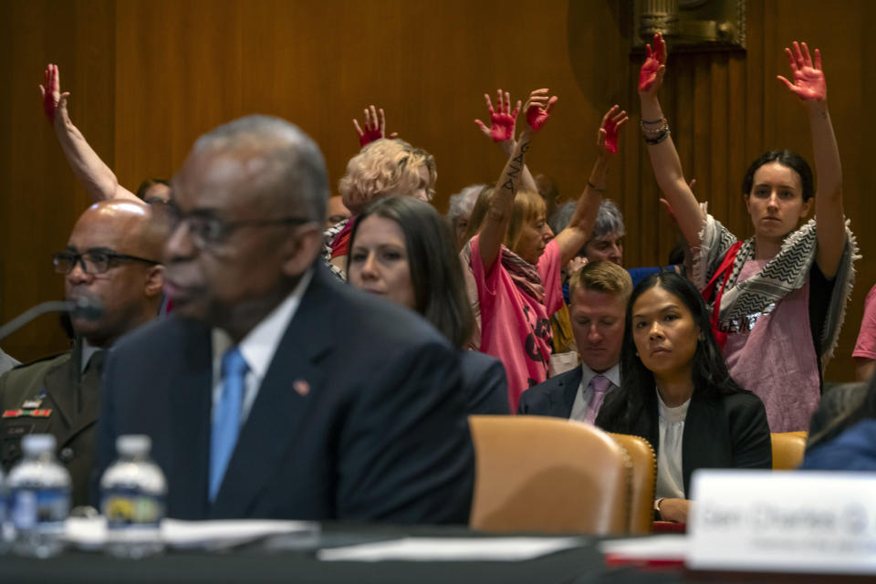 Protestors opposed to the Israel-Hamas war are escorted out as Secretary of Defense Lloyd Austin, left, speaks during a hearing of the Senate Appropriations Committee Subcommittee on Defense on Capitol Hill, Wednesday, May 8, 2024, in Washington. (AP Photo/Mark Schiefelbein)