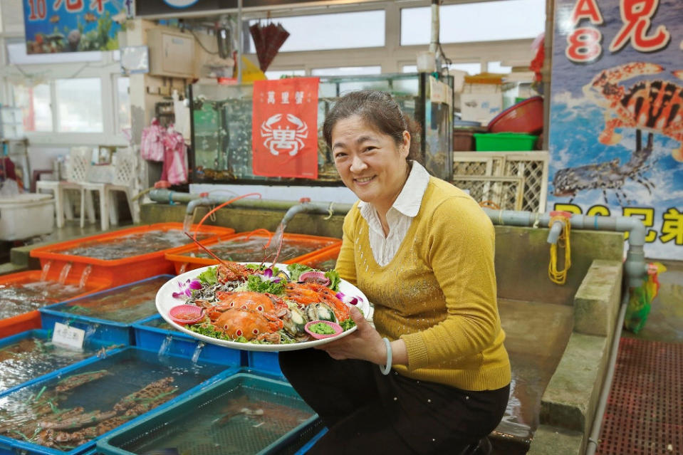 富基攤商手拿攤商自己組的海鮮拼盤，裡有龍蝦、三點蟹、海蝦、貢寮鮑等，笑容滿面，餐盤裡的海鮮令人垂涎欲滴(圖片來源：新北市政府漁業及漁港事業管理處)