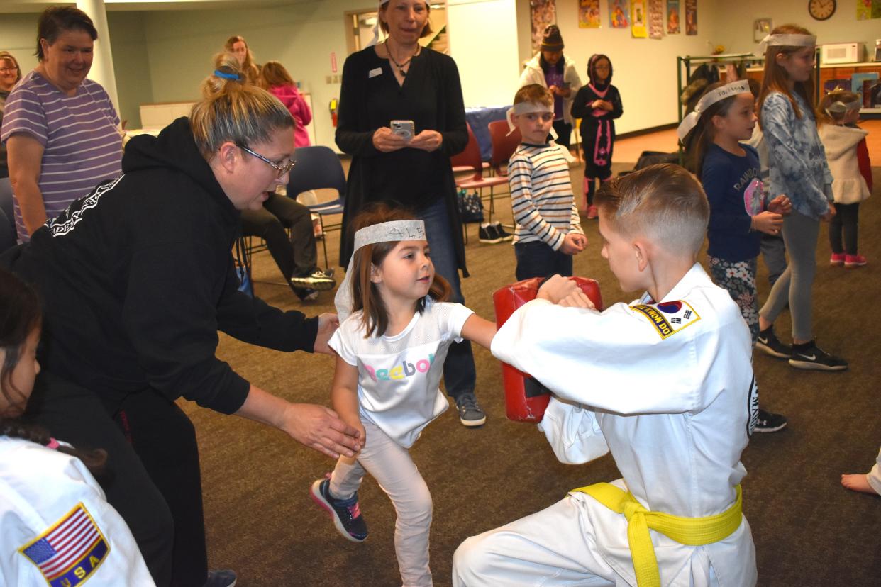 Alex Olguin, 4, of Adrian practices a forward punching technique with the assistance of Amber Lilly, left, an instructor of martial arts at Adrian's Black Dragon's Den Martial Arts Academy during the "Ninja Saturday at the Library" program April 30 at the Adrian District Library.