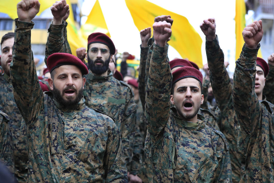 Hezbollah fighters raise their fists and shout slogans during the funeral of their senior commander Ali Dibs who was killed by an Israeli airstrike Wednesday night, in Nabatiyeh town, south Lebanon, Friday, Feb. 16, 2024. Israel's military said it killed a senior commander with the militant Hezbollah group's elite Radwan Force, Ali Dibs, who it says played a role in an attack inside Israel last year that unnerved Israelis, as well as other attacks directed at Israel over the past four months. (AP Photo/Mohammed Zaatari)