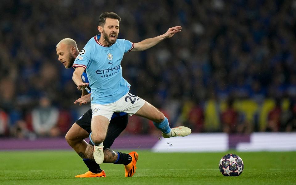 Inter Milan's Federico Dimarco, left, tackles Manchester City's Bernardo Silva - AP