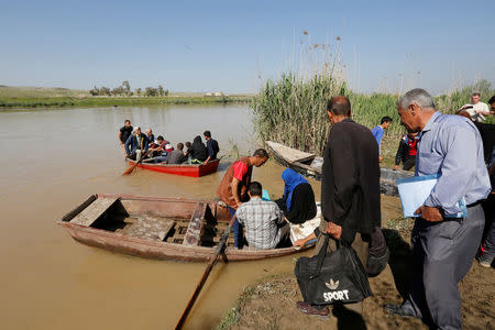 Displaced Iraqis from Mosul cross the Tigris by boat as flooding after days of rainfall has closed the city's bridges, at the village of Thibaniya, south of Mosul. REUTERS/Muhammad Hamed