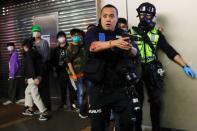 A police officers holds his gun as he is surrounded by anti-government protesters after a clash, at Mong Kok, in Hong Kong