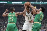 Milwaukee Bucks' Giannis Antetokounmpo tries to drive between Boston Celtics' Kemba Walker and Marcus Smart during the first half of an NBA basketball game Thursday, Jan. 16, 2020, in Milwaukee. (AP Photo/Morry Gash)
