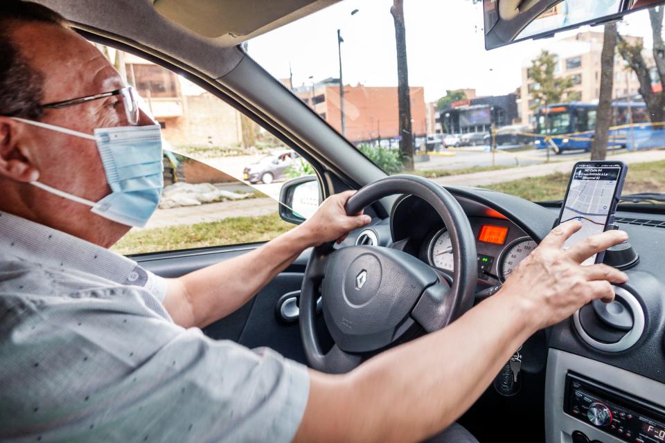 Uber driver using mobile app and GPS to check destination and directions.