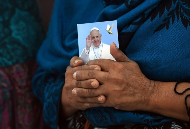 A Bangladeshi Christian woman holds a picture of Pope Franics during mass in Dhaka ahead of his arrival